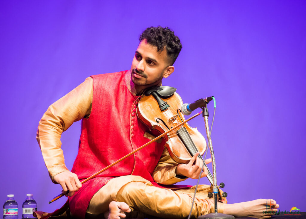 Achi Bala performing a Carnatic violin concert in a red kurta