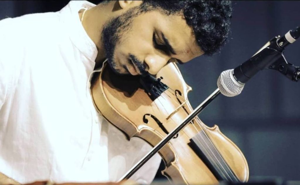 Achi Bala in a close-up moment performing into the violin